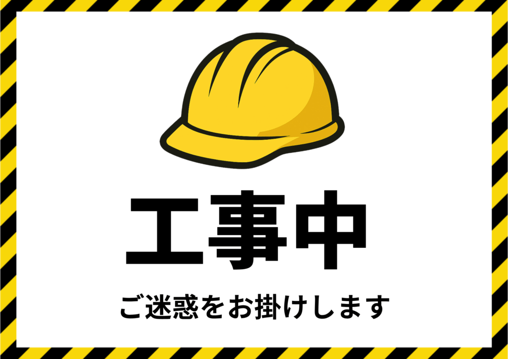 「工事中」と大きく赤文字で書かれた張り紙。黄色と黒の注意ラインに囲まれたデザインで、作業員がヘルメットをかぶってお辞儀をしているイラストと共に、「ただいま工事中です　ご迷惑をお掛けしております」と記載されている