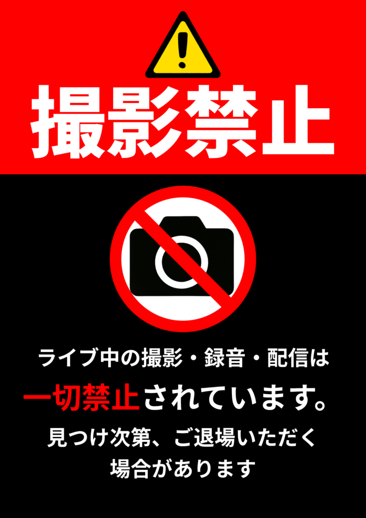 赤と黒の背景に「撮影禁止」の文字。カメラに赤い禁止マークのイラストとともに、下部には「ライブ中の撮影・録音・配信は一切禁止されています。見つけ次第、ご退場いただく場合があります」と厳重な警告文が記載されている
